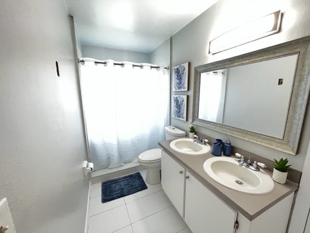 Bathroom with a double vanity, large mirror and walk-in shower at a Serenity Living home